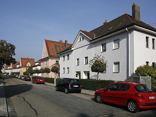 Foto, Straße mit mehreren Doppelhäusern und weiteren Wohnhäusern. 