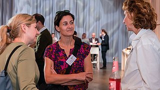 Foto, drei Frauen im Gespräch miteinander.