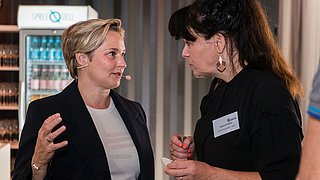 Foto, zwei Frauen im Gespräch miteinander.