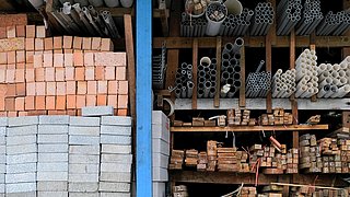 Foto, frontale Ansicht eines Regals mit verschiedenen Holz-, Stein- und Metallbaustoffen.