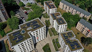 Foto, Luftbild von mehreren mehrstöckigen Gebäuden mit Gründächern und Solaranlagen.