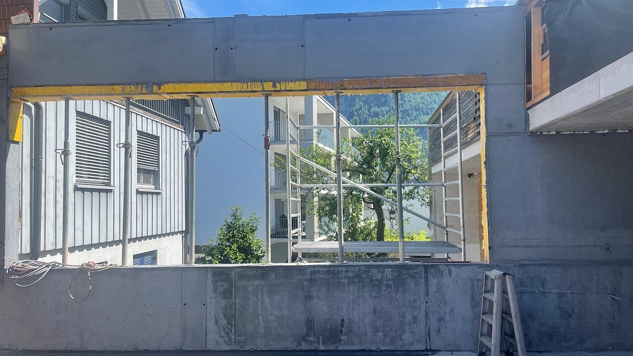 Foto, eine neu gebaute Betonwand mit Fensterausschnitt.