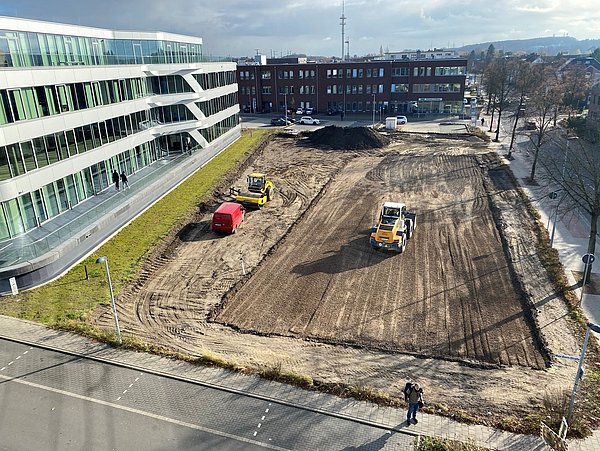 Foto, Aufnahme aus der Vogelperspektive einer Baustelle mit großer freier Fläche.