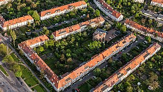 Foto, Luftbild einer städtischen Siedlung bestehend aus Mehrfamilienwohnhaus-Blöcken, einzeln stehende Mehrfamilienwohnhäusern sowie einigen Einfamilienwohnhäusern.
