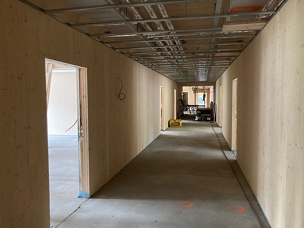Foto, im Bau befindlicher Gang im Innenraum mit Holzwänden