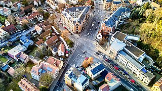 Foto, Aufnahme von oben auf eine Straßenkreuzung in einer urbanen Umgebung.
