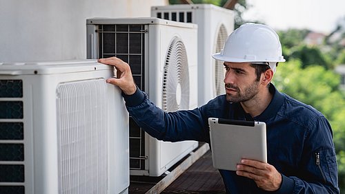 Foto, Ein Techniker mit Schutzhelm inspiziert mit einem Tablet in der Hand Klimaanlagen.