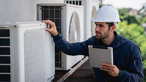 Foto, Ein Techniker mit Schutzhelm inspiziert mit einem Tablet in der Hand Klimaanlagen.