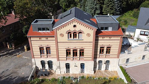 Foto, Ansicht aus der Vogelperspektive auf ein mehrgeschossiges Haus mit Klinkerfassade.