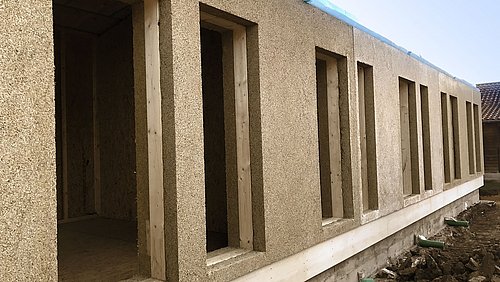 Foto, Blick auf einen einstöckige Fassade im Rohbauzustand, bei der Miscanthus (Chinaschilf) als Baustoff zum Einsatz kam.