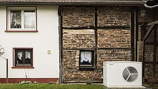 Foto, Teilansicht eines Hauses mit Fachwerkfassade mit Außentechnik einer Wärmepumpe