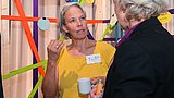 Foto, zwei Frauen im Gespräch auf einer Veranstaltung.