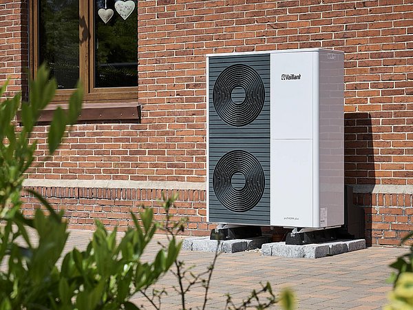 Foto, Wärmepumpe von Vaillant steht vor Haus mit rotem Backstein