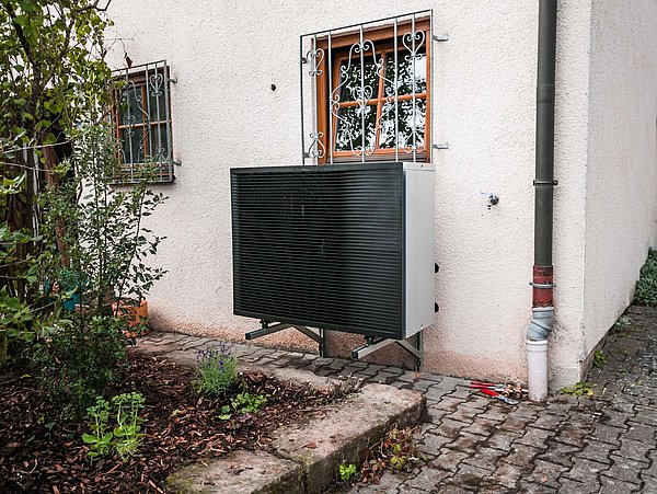 Foto, außen befindliche Anlagentechnik einer Wärmpumpe vor einem Einfamilienhaus