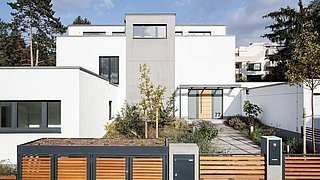 Foto, Straßenansicht auf ein modernen Einfamilienhaus mit großem Holztor im Vordergrund