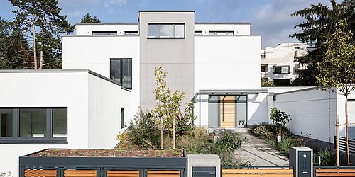 Foto, Straßenansicht auf ein modernen Einfamilienhaus mit großem Holztor im Vordergrund