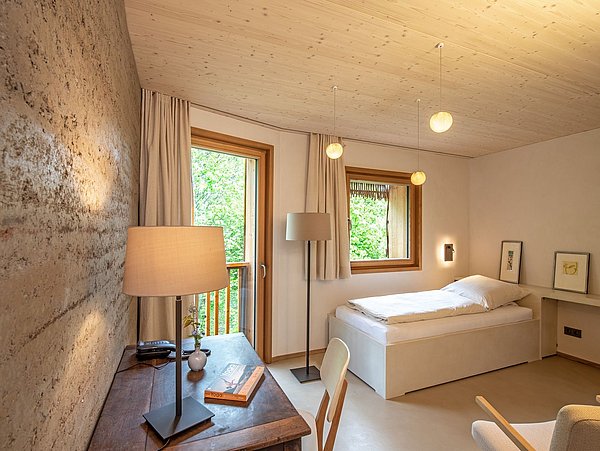 Foto, Innenansicht eines kleinen Schlafzimmers mit Einzelbett und Schreibtisch.