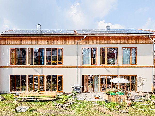 Foto, Fensterfront Sonnenseite des Strohballenhauses.