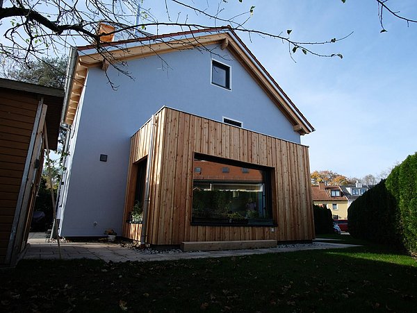 Foto, Außenansicht des Einfamilienhauses mit teilweiser Holzverkleidung. 