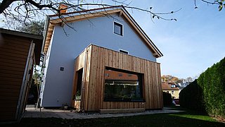 Foto, Außenansicht des Einfamilienhauses mit teilweiser Holzverkleidung. 