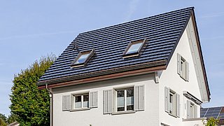 Foto, Haus mit einer dachintegrierten Photovoltaikanlage.