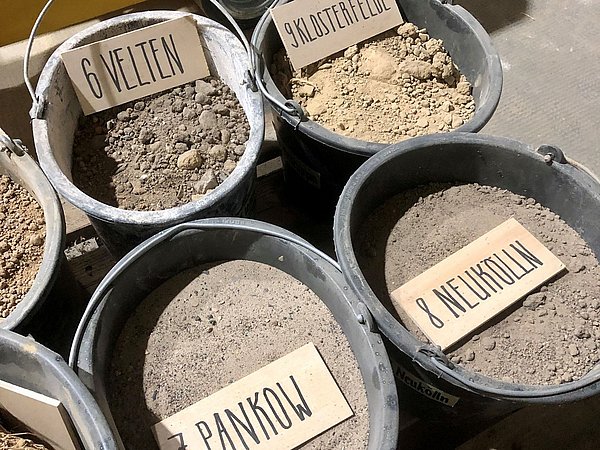 Foto, Baustellenaushub in verschiedenen Eimern sortiert.