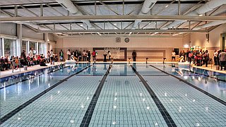 Foto, 25 Meter langes Sport-Schwimmbecken mit sechs Bahnen, Seitentreppeneinstieg und Startblöcken.