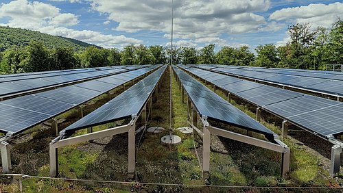 Foto, aufgeständerte Photovoltaikmodule auf dem Gründach eines Parkhauses.