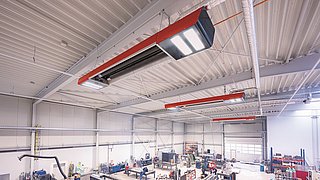 Foto, Große Industriehalle mit Maschinen und Werkbänken, Deckenstrahlern und hoher Decke mit Stahlträgern