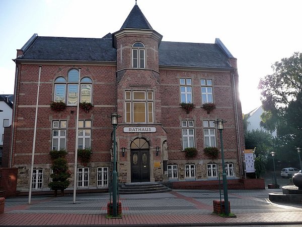 Foto, Rathaus mit Klinkerfassade und Türmchen in der Mitte des Gebäudes.