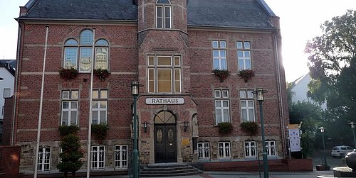 Foto, Rathaus mit Klinkerfassade und Türmchen in der Mitte des Gebäudes.