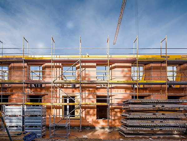 Foto, Gebäude im Aufbau. Es sind zwei Stockwerke und ein Gerüst errichtet.