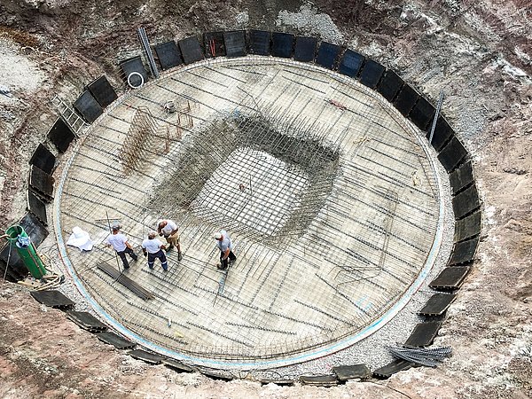 Foto, Luftaufnahme einer Baustelle eines großen, runden Eisspeichers im Boden.