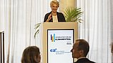 Foto, eine Rednerin wendet sich an das Publikum einer Veranstaltung.