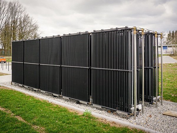 Foto, der aus schwarzen, in einem Rechteck angeordneten Rohren bestehende Energiezaun