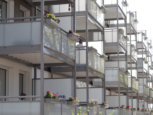 Foto, Balkone mit bepflanzten Blumenkästen an einem Mehrfamilienhaus.