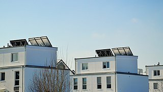 Foto, zwei Wohngebäude mit Solaranlagen auf dem Dach.