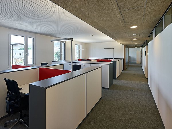 Foto, großes Büro mit mehreren Arbeitsplätzen in Reihen.