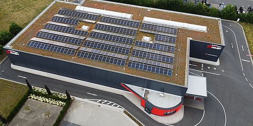 Foto, Vogelperspektive auf den Autowaschpark mit Photovoltaikanlagen auf dem begrünten Dach. 