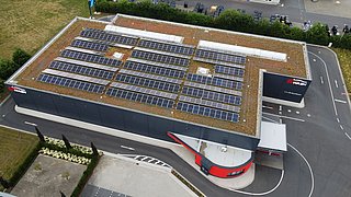 Foto, Vogelperspektive auf den Autowaschpark mit Photovoltaikanlagen auf dem begrünten Dach. 