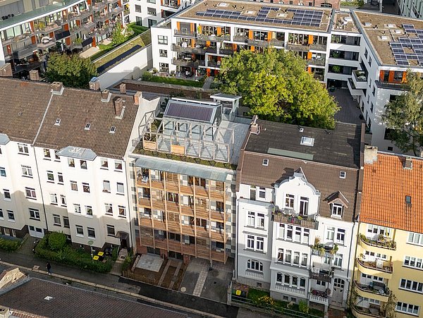 Foto, Luftaufnahme von Wohngebäuden mit begrünten Innenhöfen und Solaranlagen auf den Dächern