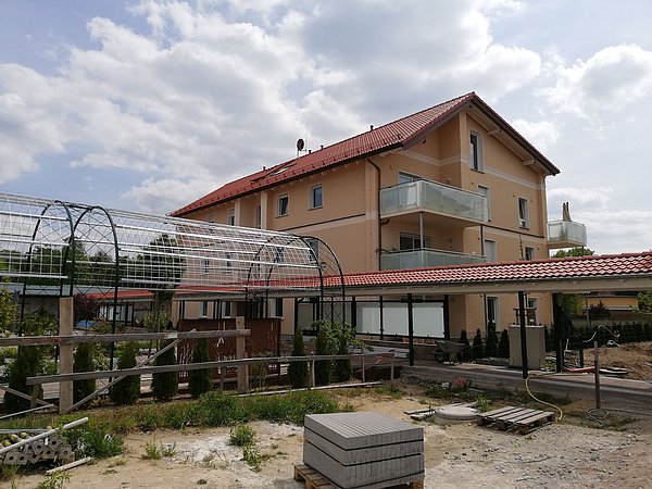 Foto, dreistöckiges Mehrfamilienhaus mit angrenzender Gartenanlage von außen
