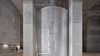 Foto, ein riesiger Großpufferspeicher in einem Betonbau.