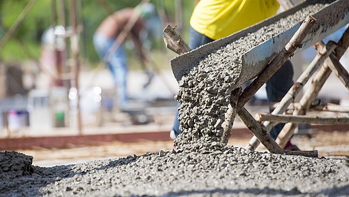Foto, flüssiger Beton wird auf dem Boden ausgegossen.