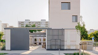 Foto, modernisiertes, kubisches Gebäude mit großen Fenstern und Garage in einer ruhigen Wohngegend.
