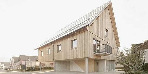 Foto, Modernes Holzhaus auf Stelzen mit Solarpaneelen auf dem Dach und kleinem Balkon