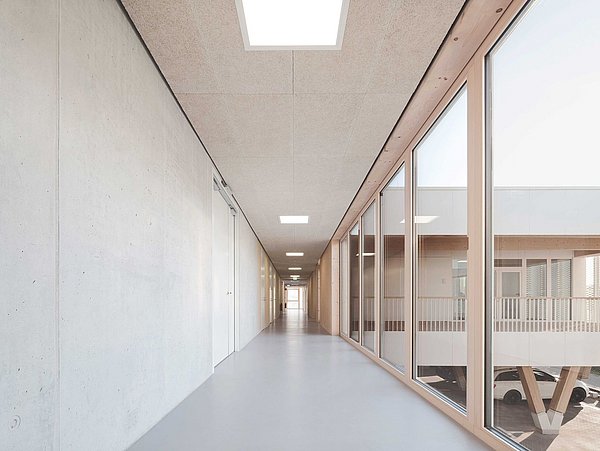 Foto, Korridor mit Fensterfront rechts und Betonwand auf der linken Seite