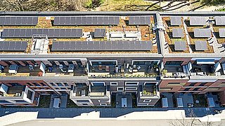 Foto, Blick von oben auf ein Gebäudedach mit Solarkollektoren.