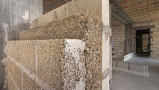 Foto, Ansicht einer Innenwand im Bauzustand, die aus verschiedenen Bauelementen mit Miscanthus (Chinaschilf) errichtet wird.