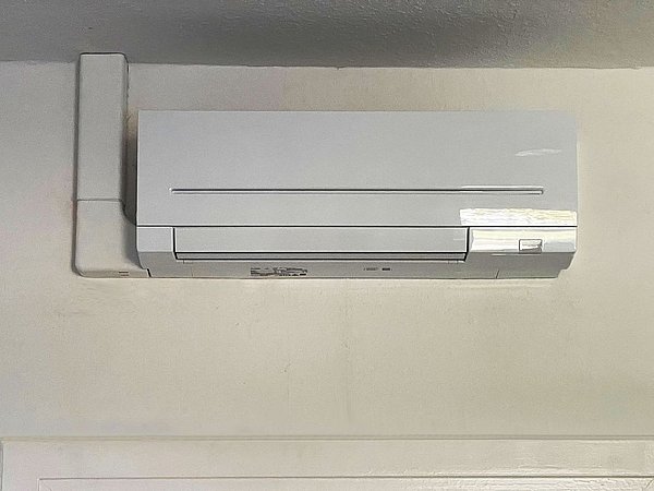 Foto, Inneneinheit einer Luft-Luft-Wärmepumpe über einer weißen Tür in einem Innenraum